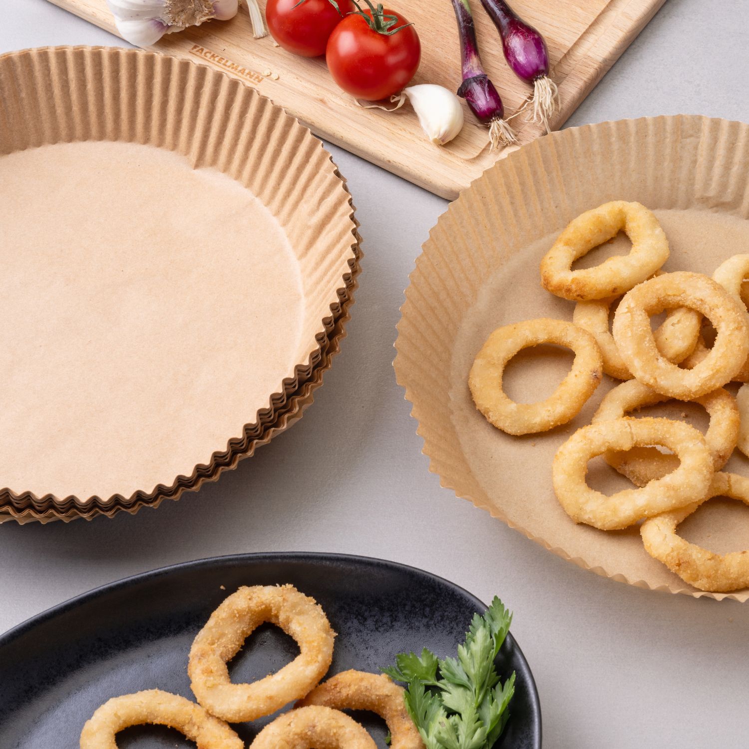 rundes Backpapier mit fertigen Zwiebelringen auf Küchenplatte