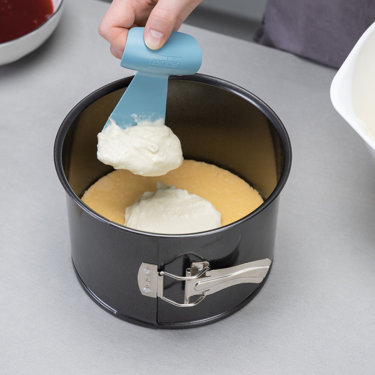 Verwendung des Zenker Patisserie Creme- und Teigverteilers zum Füllen von Creme in eine hohe Springform