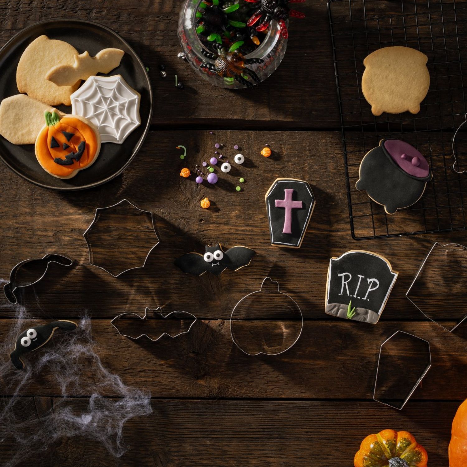 Ausstecher und Kekse des Halloween-Ausstechersets auf Holzhintergrund