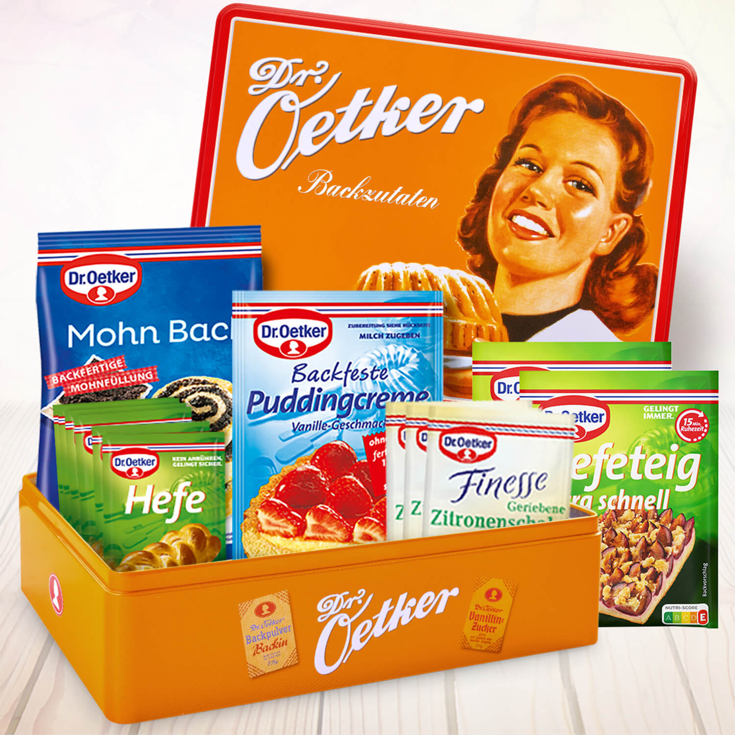 Orange Keksdose mit Retromotiv gefuellt mit verschiedenen Hefe-Backzutaten