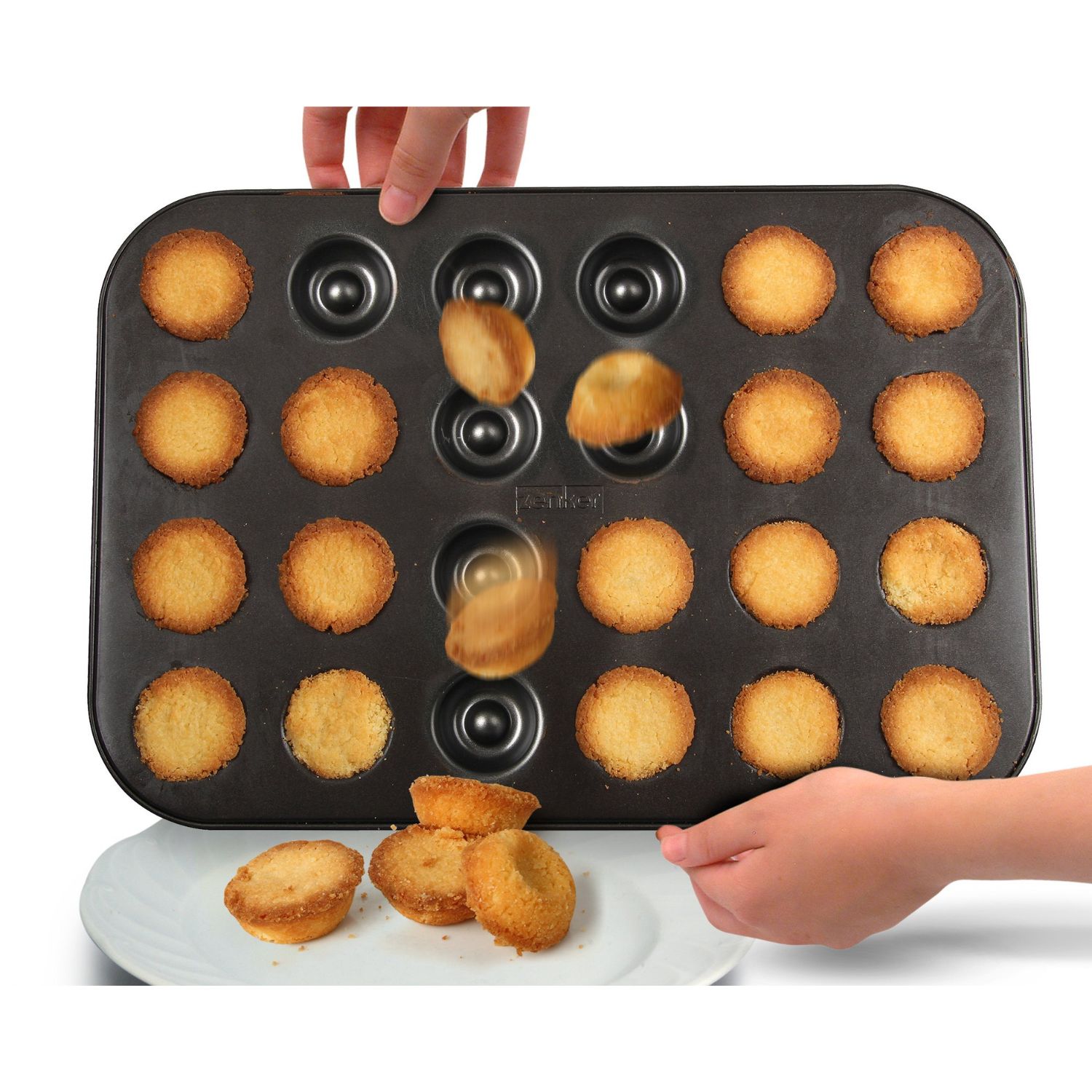 Fertige Husarenkrapfen werden aus dem Backblech geschüttet