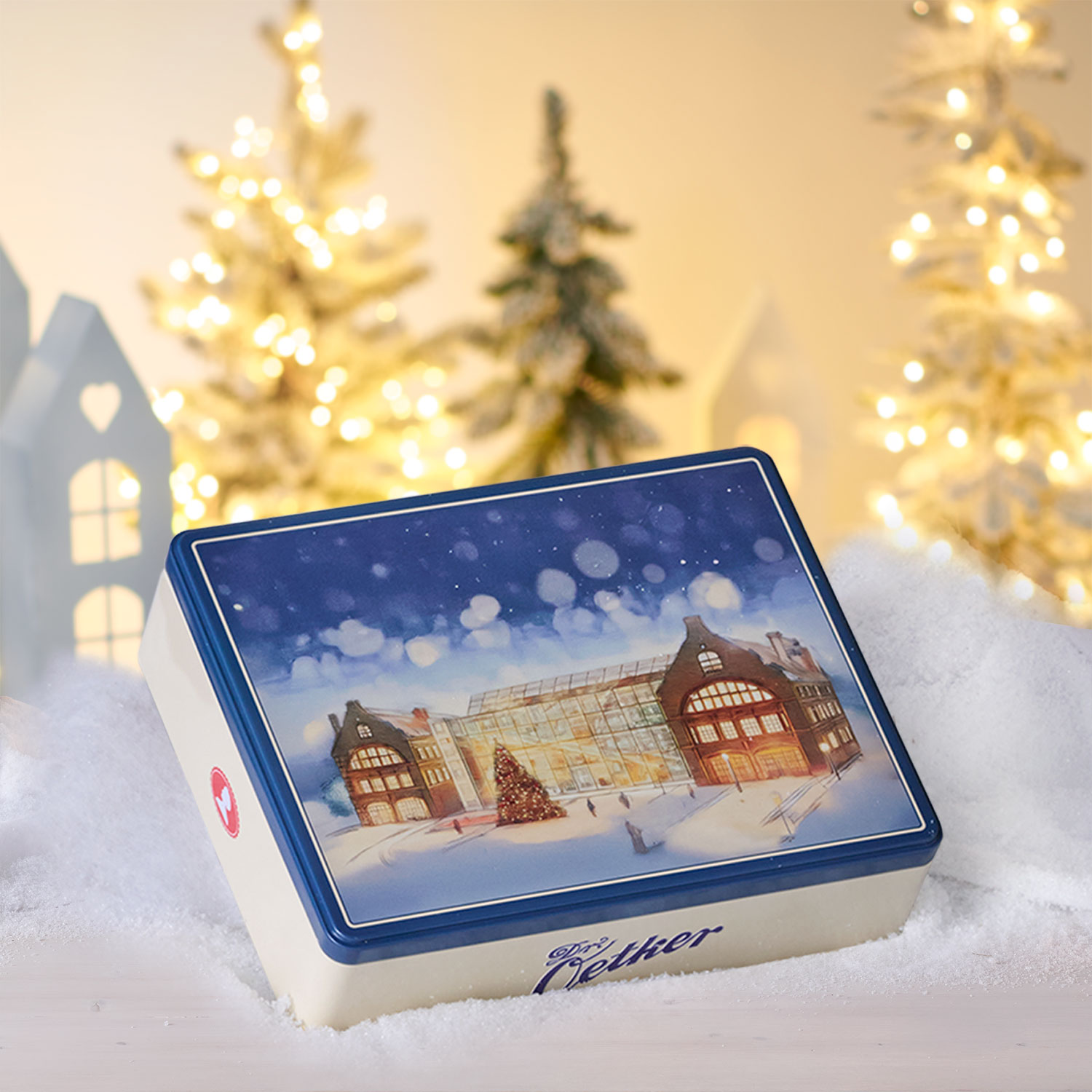 Eine Keksdose mit der Dr. Oetker Welt in winterlichem Motiv vor einem winterlichem Hintergrund