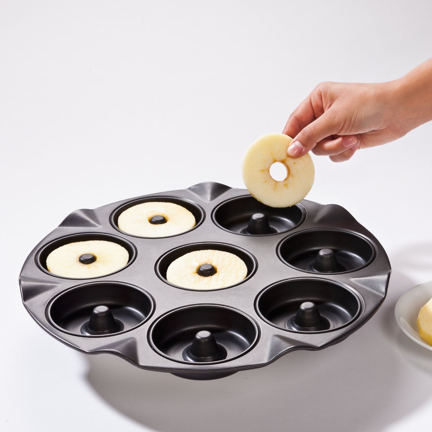 Backblech füur Apfelkuechli, in das von Hand Apfelringe getan werden