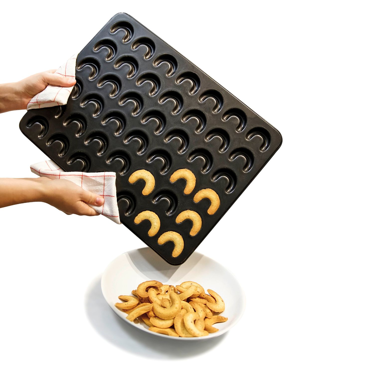 Fertige Vanillekipferl mit dem Backblech fuer Vanillekipferl werden  in eine Schale gegeben