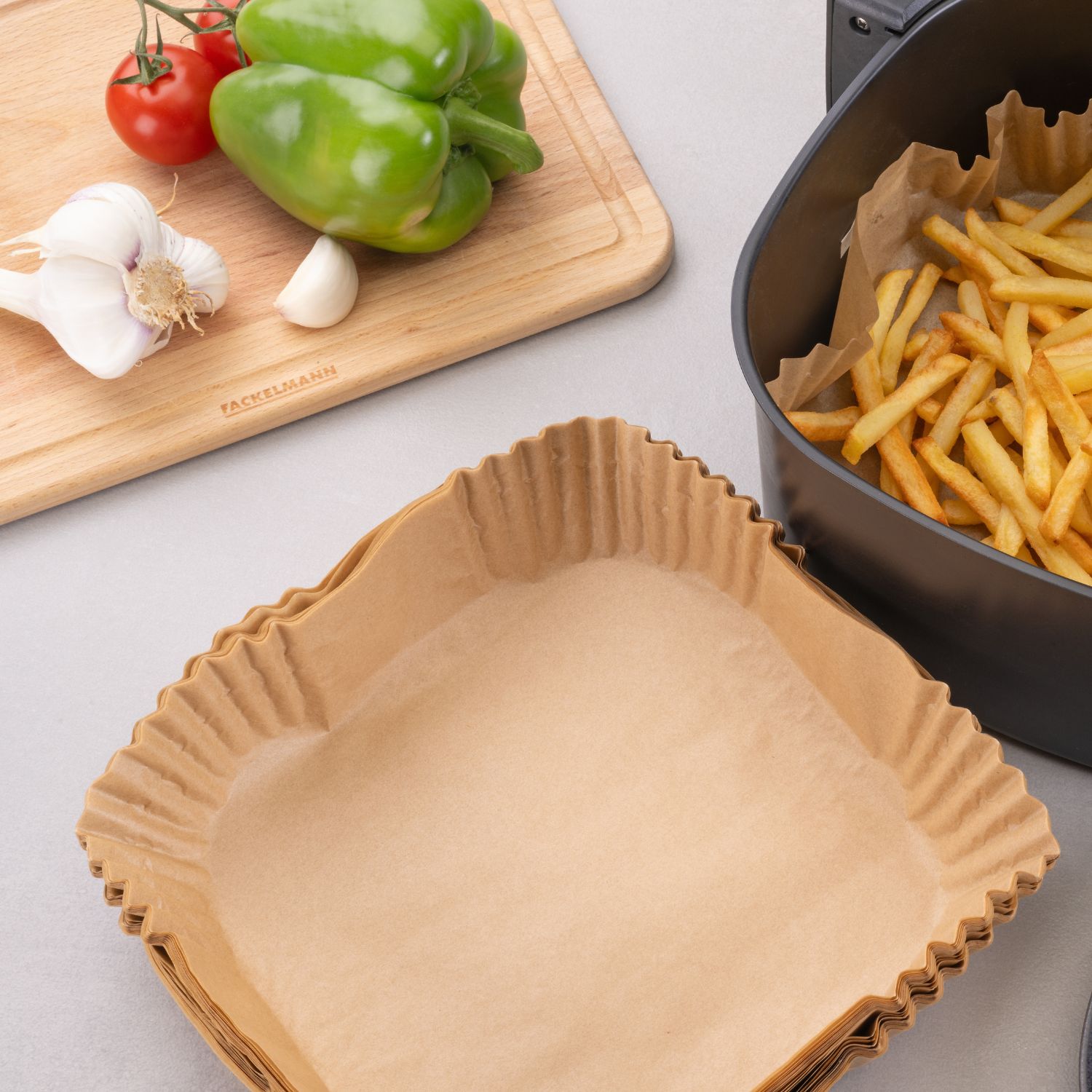 60-172541 Backpapier eckig 20 cm Heissluftfritteuse Mood Pommes Eckiges Backpapier für die Heissluftfritteuse vor dem Gerät, das Pommes enthält