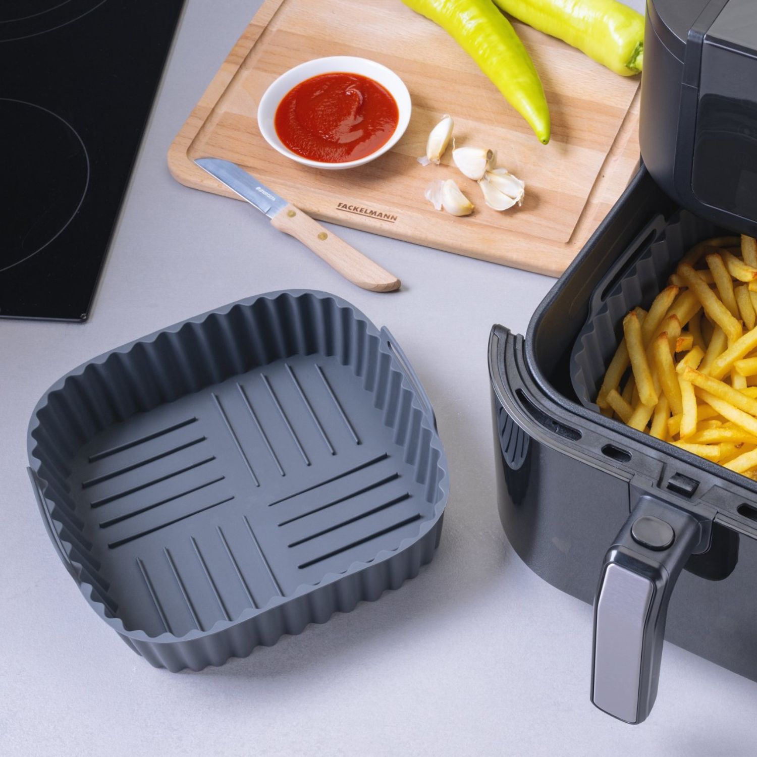 Zwei Silikonformen, eine befindet sich in der Heißluftfritteuse und ist mit Pommes gefüllt