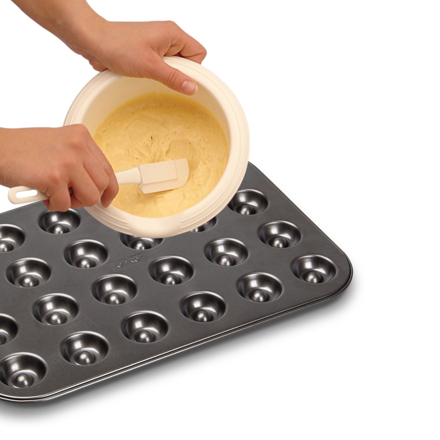 Teig aus einer Ruehrschuessel wird auf ein Backblech für Husarenkrapfen gegeben