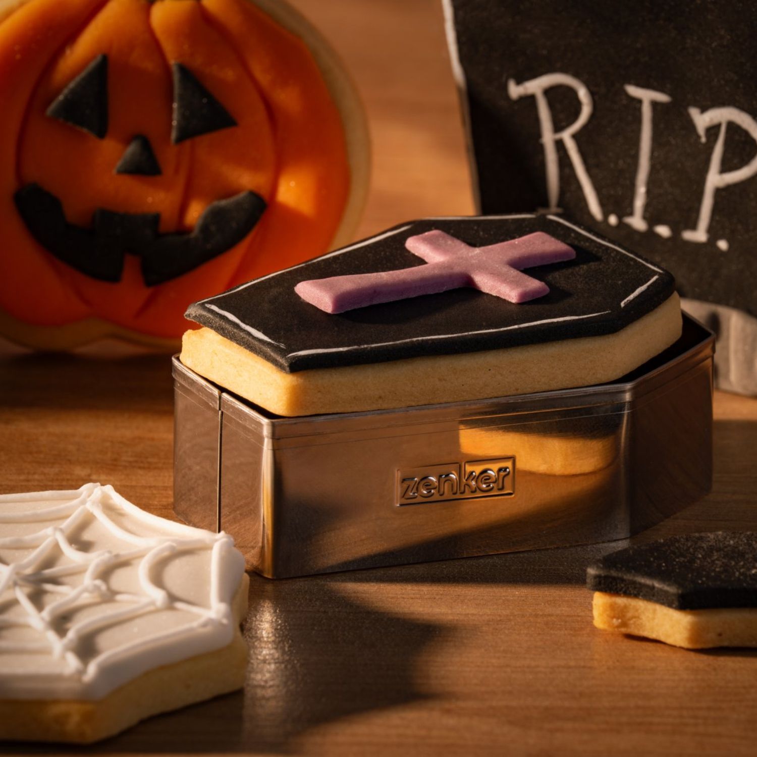 Ausstecher mit Gebäck in Halloween-Motiven Sarg und Spinnennetz vor stimmungsvollem Hintergrund
