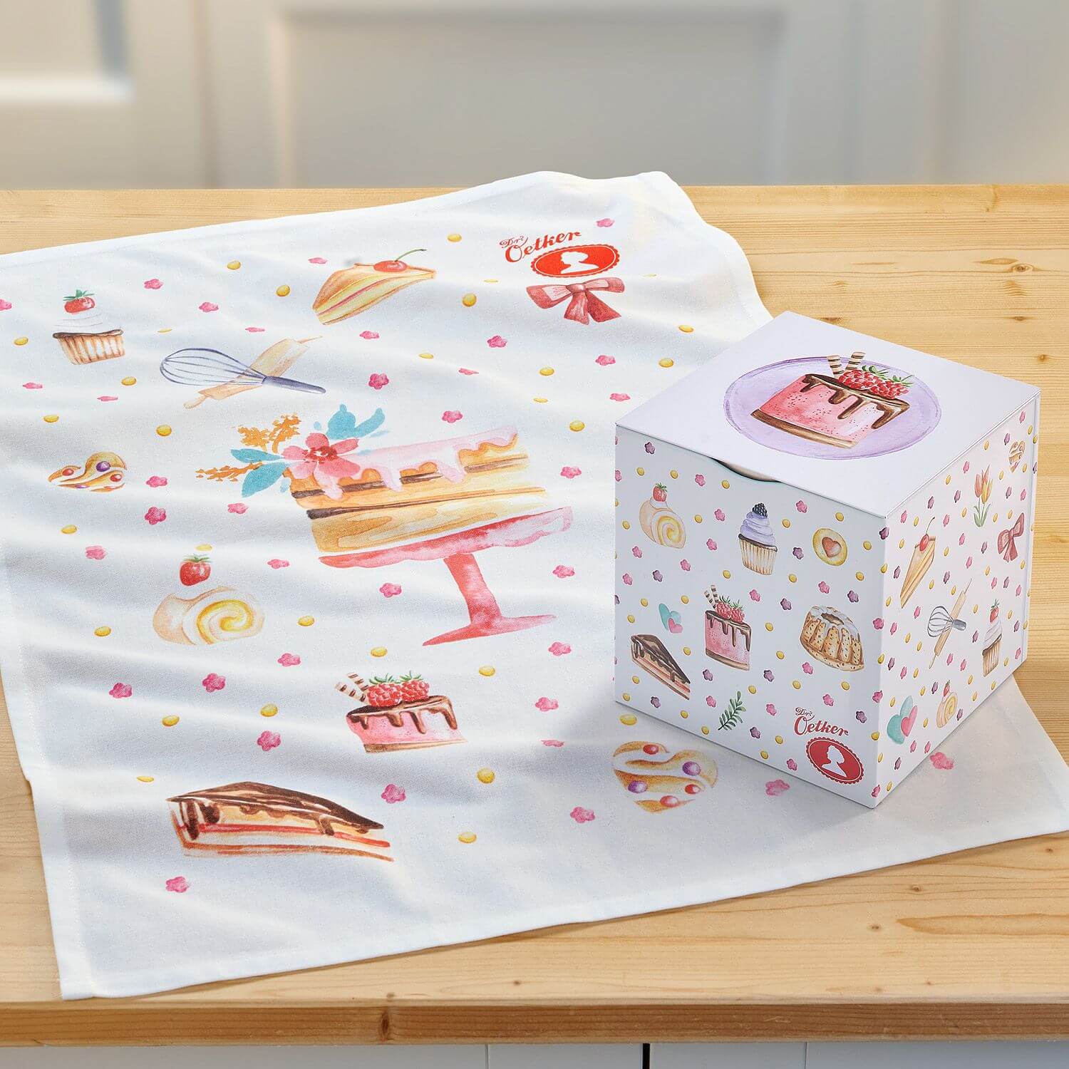 Buntes Geschirrtuch und Würfeldose auf Holzplatte