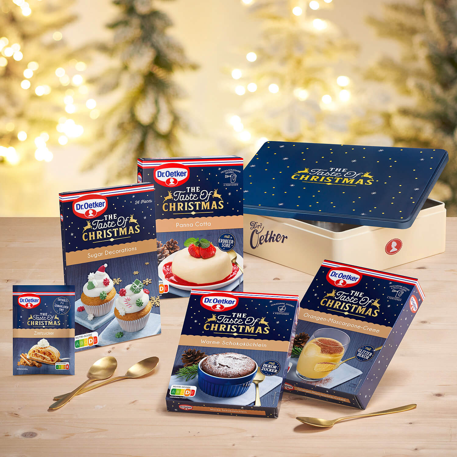 Weinachtliche Dose mit Desserts und Dekors vor stimmungsvollem weihnachtshintergrund
