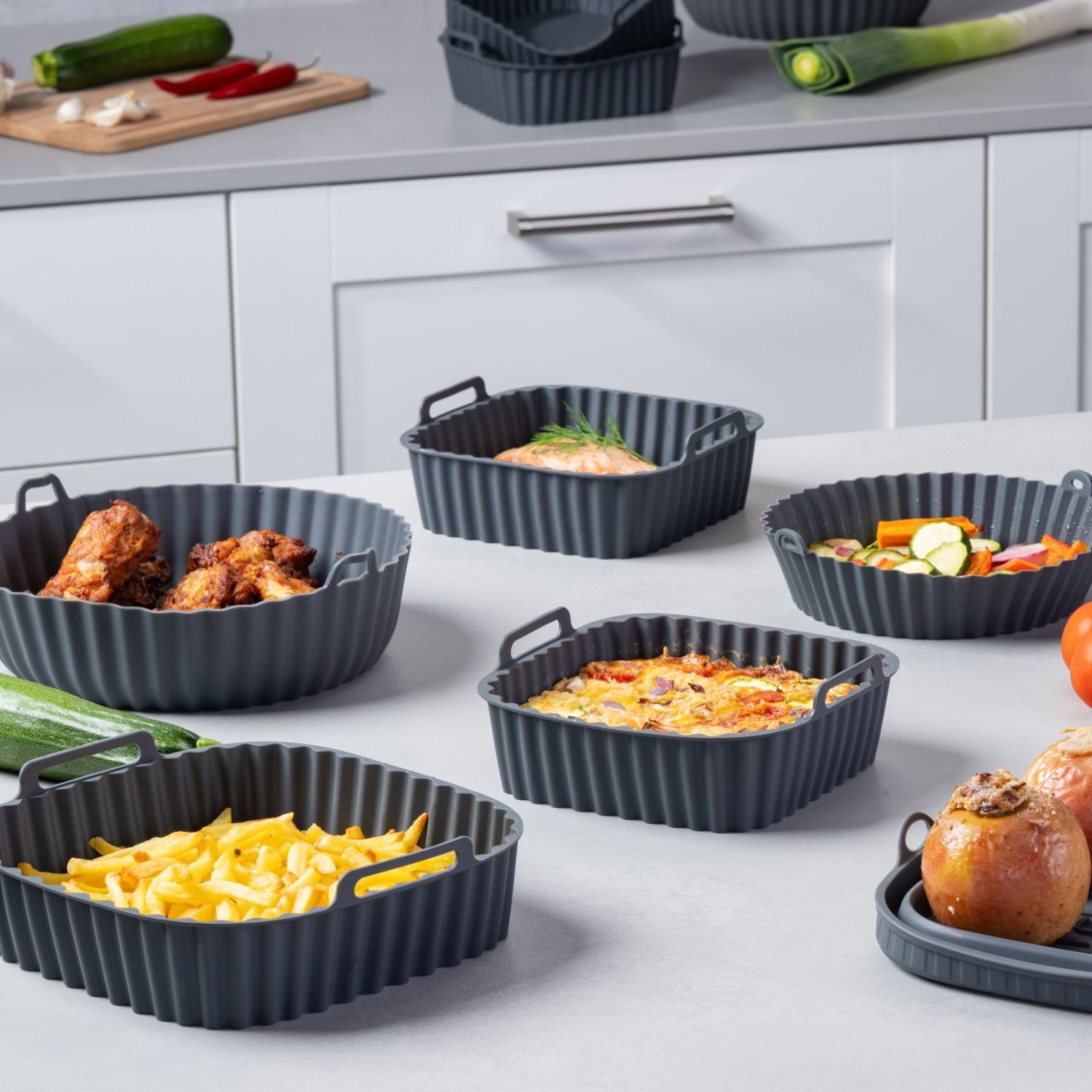 Mehrere Silikonformen in verschiedenen Größen, gefüllt mit verschiedenen Gerichten