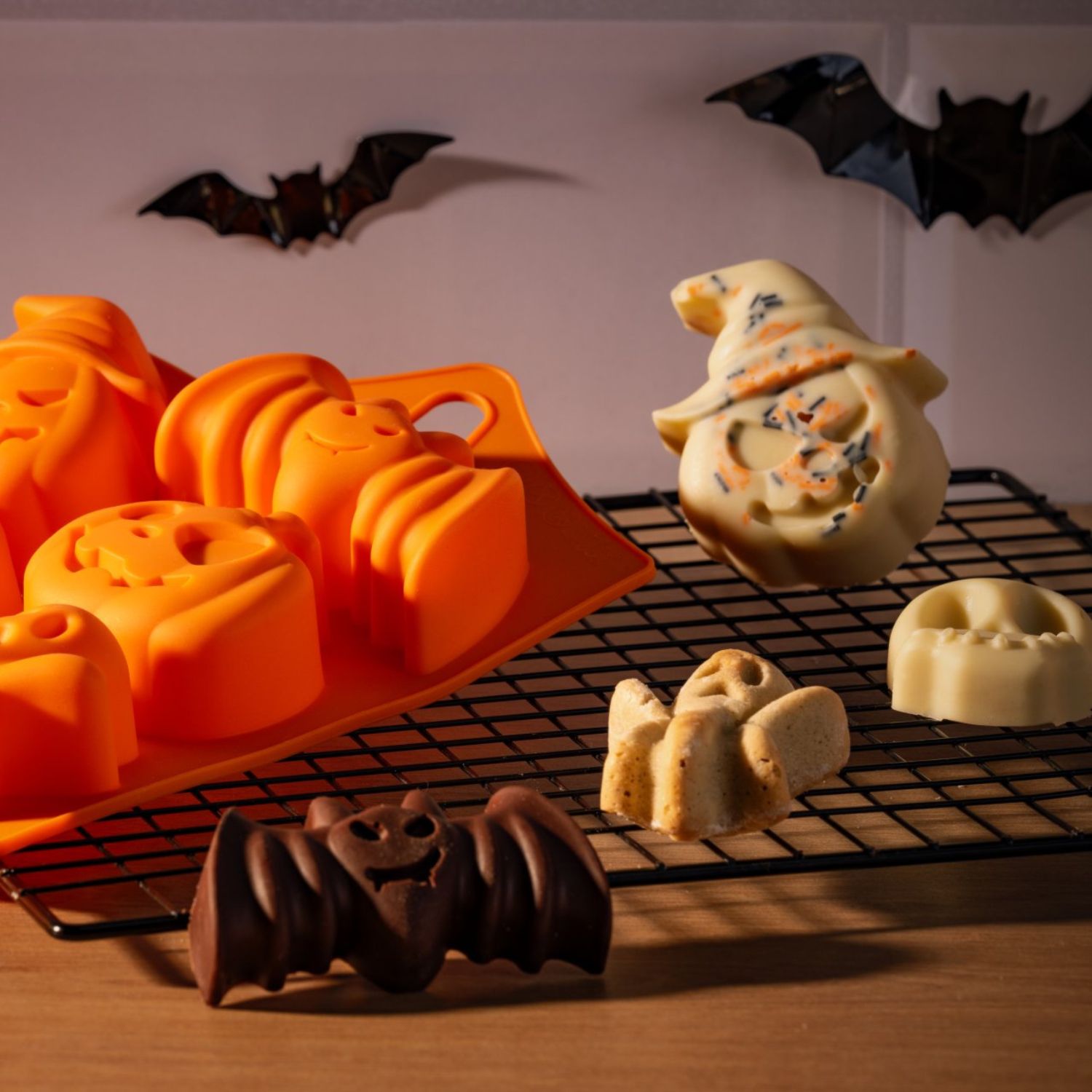 Backform aus Silikon für Minikuchen in Halloween-Motiven auf Kuchenrost mit Gebäcken in Halloween-Motiven