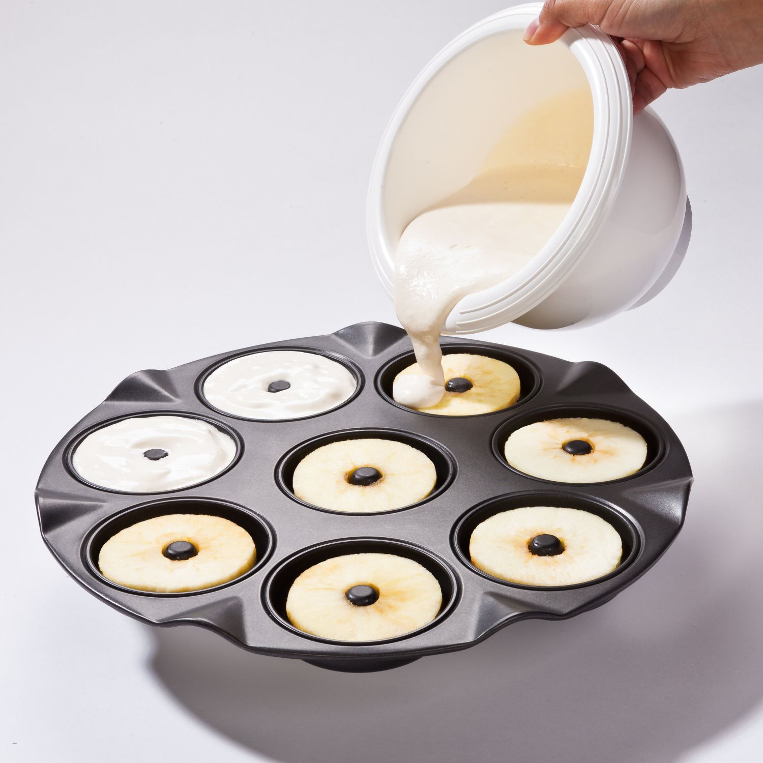 Teig aus einer Ruehrschuessel wir in ein Backblech für Apfelkuechli gegeben