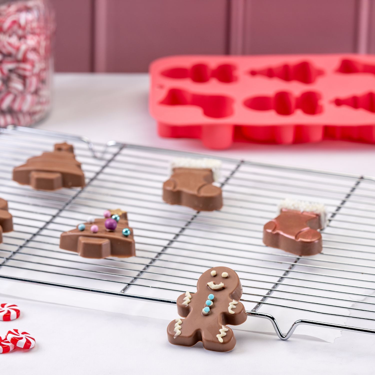 Schokolade aus der Silikonform Weihnachtliche Motive von Zenker auf Kuchenrost vor dekorativem Hintergrund