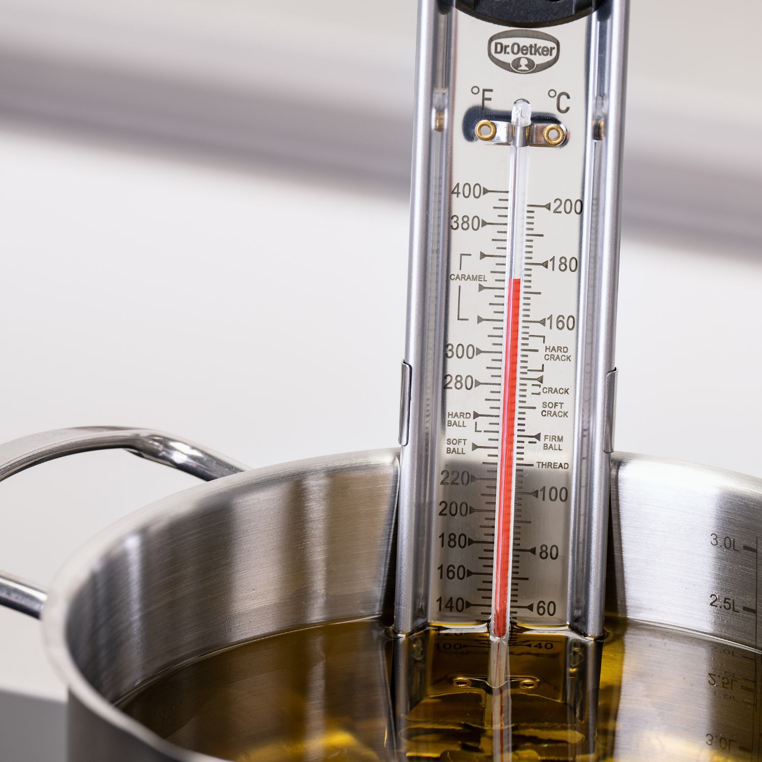 Zuckerthermometer in Kochtopf mit Öl am Rand des Topfes befestigt
